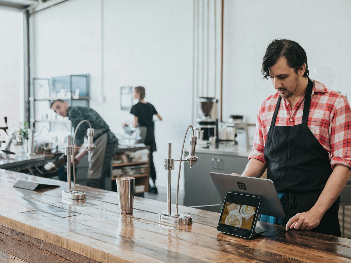 A staff member operating a point-of-sale system behind the counter