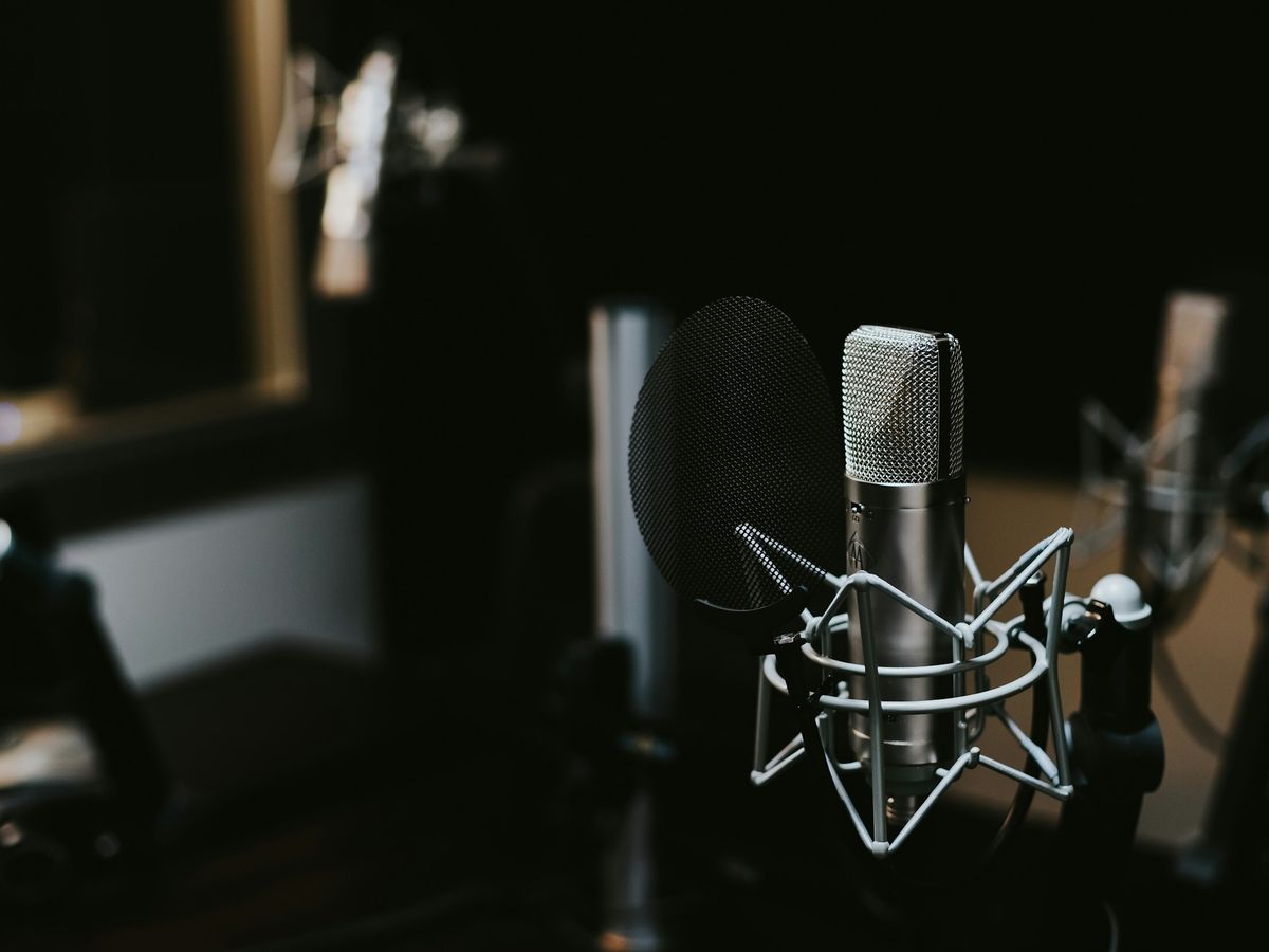 A studio microphone in a darkened recording room
